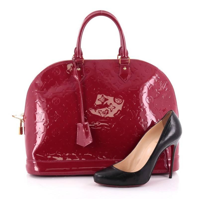 This authentic Louis Vuitton Alma Handbag Monogram Vernis GM is a fresh and elegant spin on a classic style that is perfect for all seasons. Crafted from Louis Vuitton's red monogram vernis, this dome-shaped satchel features dual-rolled handles,