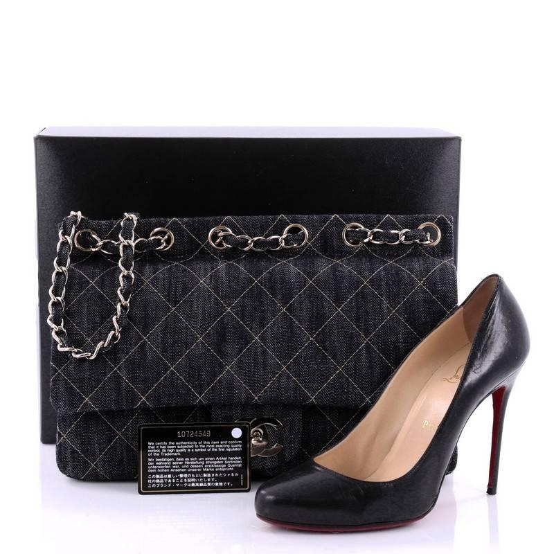 This authentic Chanel Chain Through Flap Bag Quilted Denim Jumbo is perfect for daytime wear. Crafted in dark blue quilted denim, this classic Chanel flap features woven-in denim chain strap that is laced through the top of the bag, exterior back