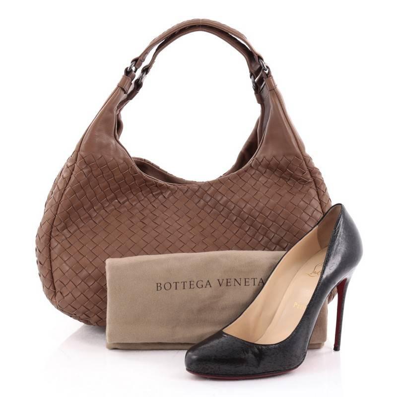 This authentic Bottega Veneta Campana Hobo Intrecciato Nappa Small is both understated yet elegant perfect for the modern woman. Crafted in Bottega Veneta's signature intrecciato woven light brown nappa leather, this functional shoulder bag features