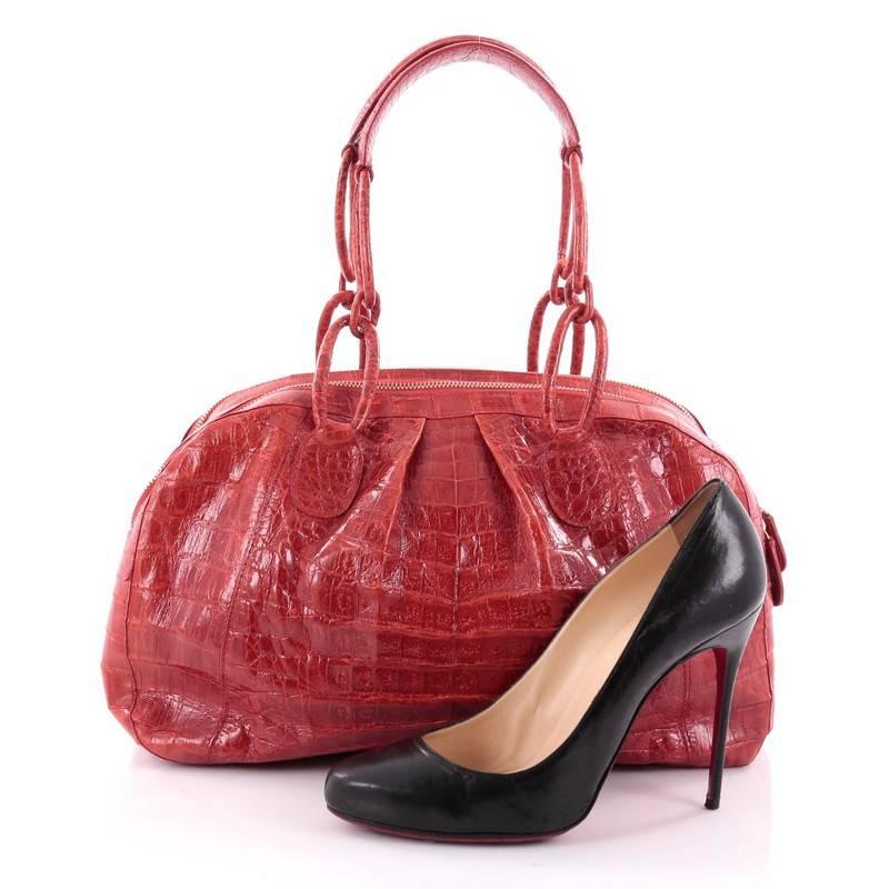 This authentic Nancy Gonzalez Bowler Bag Pleated Crocodile Medium is perfect for everyday use. Crafted in genuine red crocodile skin, this feminine bag features pleated silhouette, wrapped chain-link straps with shoulder pads, protective base feet