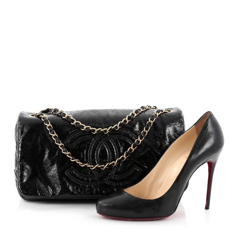This authentic Chanel Rock and Chain Flap Bag Patent Vinyl Medium boast a stature perfect for Chanel lovers. Crafted in black patent vinyl, this bag features signature woven-in leather chain straps, large CC stitched design on its front flap,
