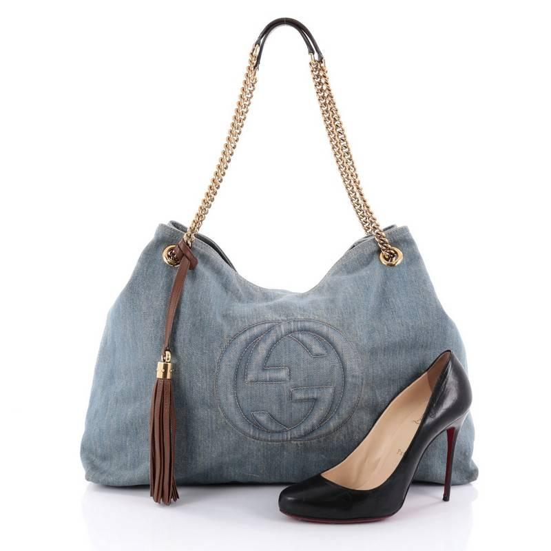 This authentic Gucci Soho Shoulder Bag Chain Strap Denim Large is simple yet stylish in design. Crafted from light blue denim, this tote features chain strap with leather pads, brown leather fringe tassels, signature interlocking Gucci logo stitched