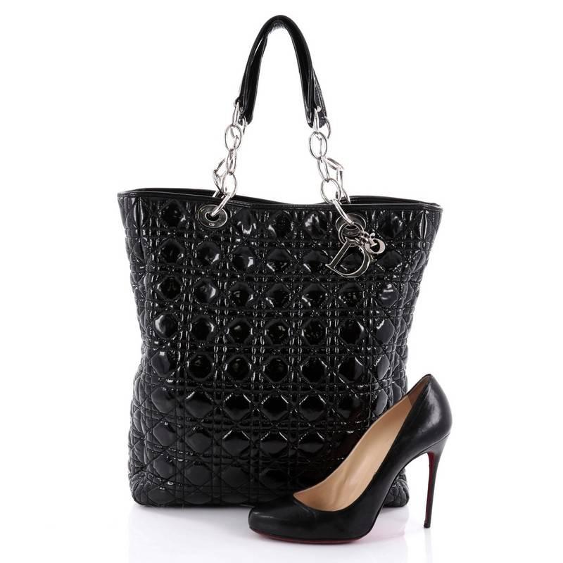 This authentic Christian Dior North South Soft Chain Tote Cannage Quilt Patent Medium is a perfect bag for your days or nights out. Crafted from black cannage quilted patent leather, this chic elongated tote bag features dual chain-link straps with