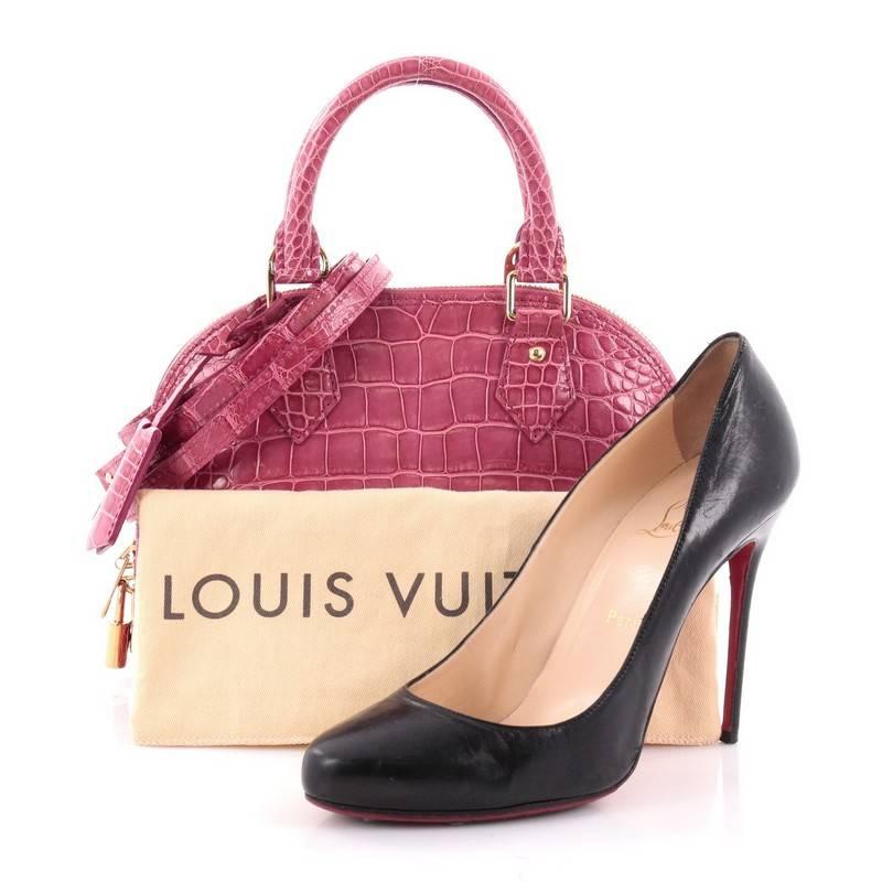 This authentic Louis Vuitton Alma Handbag Crocodile BB is a chic and sophisticated bag perfect for everyday use. Constructed in genuine pink crocodile skin, this petite dome-like bag features a sturdy base, protective base studs, dual-rolled