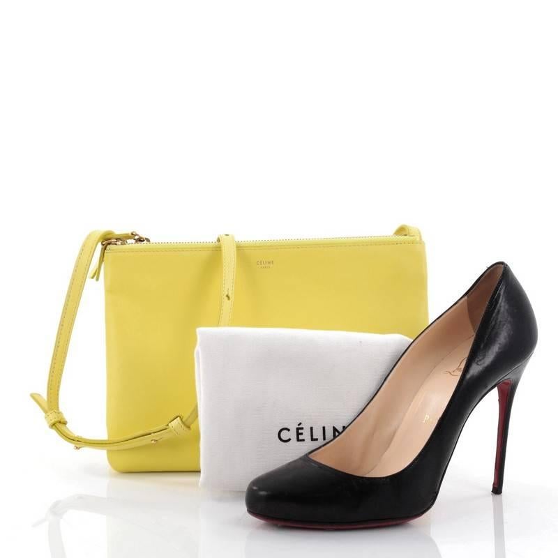 This authentic Celine Trio Crossbody Bag Leather Large is a minimalist crossbody perfect for on-the-go moments. Crafted from neon yellow leather, this impossibly chic bag features adjustable shoulder strap, gold-tone snap buttons that easily