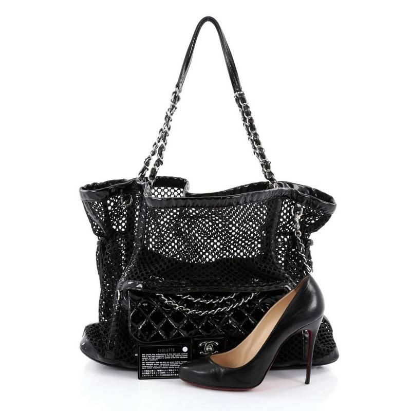 This authentic Chanel La Madrague Tote Mesh and Patent is an excellent tote for day or evening use. Crafted from black mesh and patent leather, this bag features woven-in leather chain handles with shoulder pads, external removable frontal patent