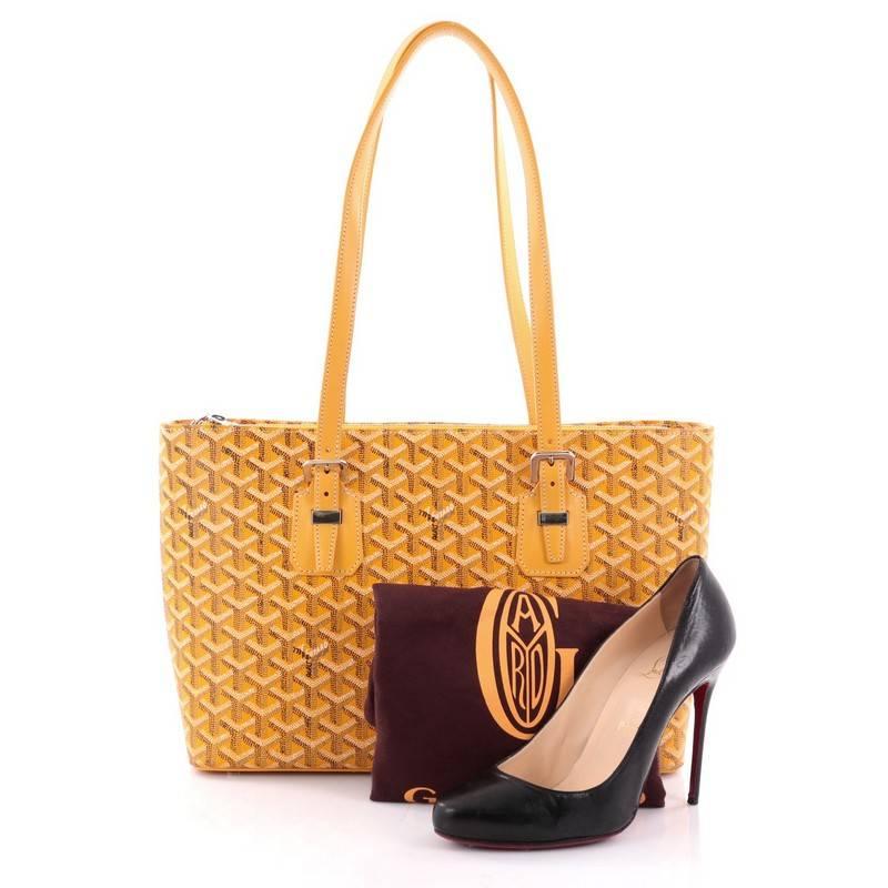 This authentic Goyard Okinawa Handbag Canvas PM displays a luxurious and casual sophistication perfect for travel or everyday use. Crafted from yellow Goyard chevron coated canvas, this bag features dual flat shoulder straps with buckle detailing,