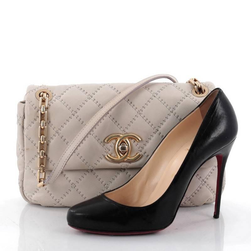 This authentic Chanel Retro Chain Flap Bag Quilted Leather Medium is a casual-cool bag perfect for everyday use. Crafted from light gray embossed leather with Chanels' diamond quilted design, this flap bag features dual chain-link straps with