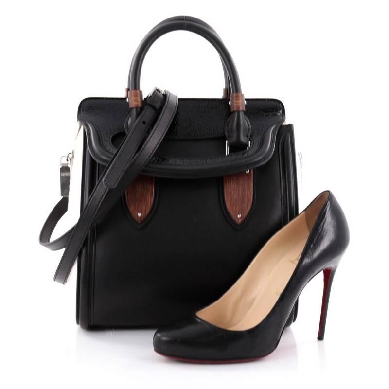 This authentic Alexander McQueen Wood Plate Heroine Tote Leather with Calf Hair Medium combines functional style with luxurious design. Constructed in sleek black leather, this bag features unique white calf hair side panels, wood-plate accents,