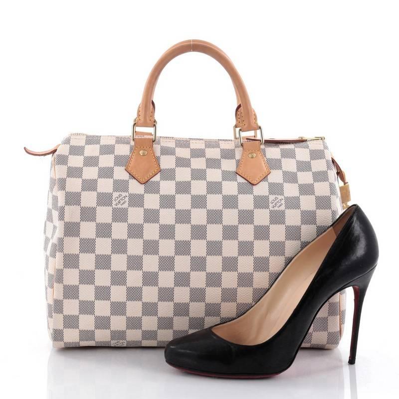 This authentic Louis Vuitton Speedy Handbag Damier 30 is a timeless favourite of many. Constructed from Louis Vuitton's signature damier azur coated canvas, this iconic Speedy features dual-rolled handles, vachetta leather trims and gold-tone
