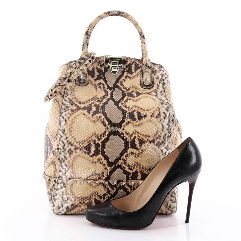 This authentic Valentino Rockstud New Dome Convertible Bucket Bag Python combines a refined design with stylish functionality perfect for the on-the-go fashionista. Crafted from genuine light yellow python, this structured bucket-style tote features