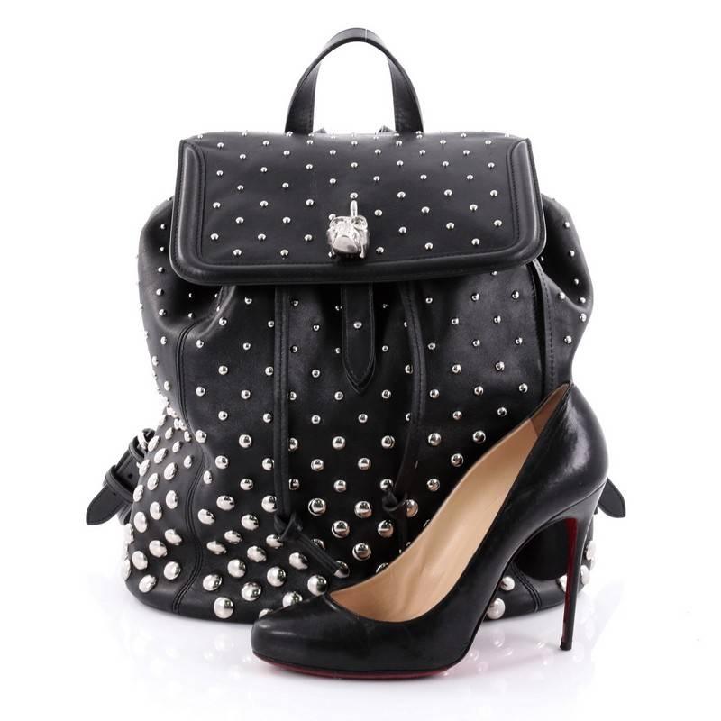 This authentic Alexander McQueen Skull Padlock Backpack Studded Leather Large is a sleek and stylish accessory with a tough-girl edge made for every fashionista. Crafted in supple black leather with silver studded detailing, this eye-catching,