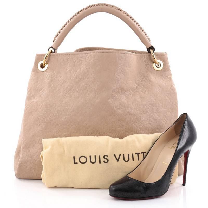 This authentic Louis Vuitton Artsy Handbag Monogram Empreinte Leather MM is as elegant as it is sturdy. Crafted from nude monogram embossed empreinte leather, this luxurious and refined hobo features a single looped braided top handle with polished