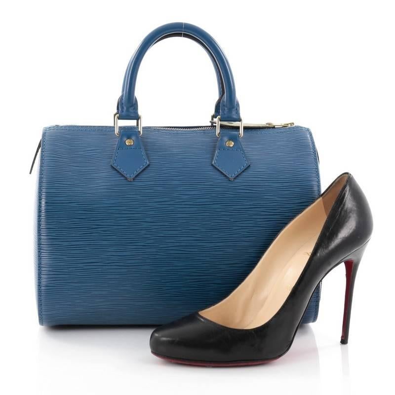 This authentic Louis Vuitton Speedy Handbag Epi Leather 25 is a timeless favorite of many. Crafted in blue epi leather, this bag features dual-rolled handles, subtle stamped LV logo, exterior side slip pocket and gold-tone hardware accents. Its top