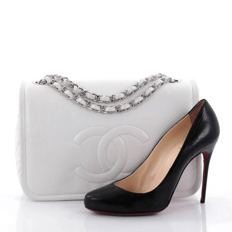 This authentic Chanel Timeless CC Flap Bag Caviar Large showcases the brand's classic style with a fresh, modern twist perfect for the modern woman. Crafted from white caviar leather, this elegant full flap bag features a stitched interlocking CC