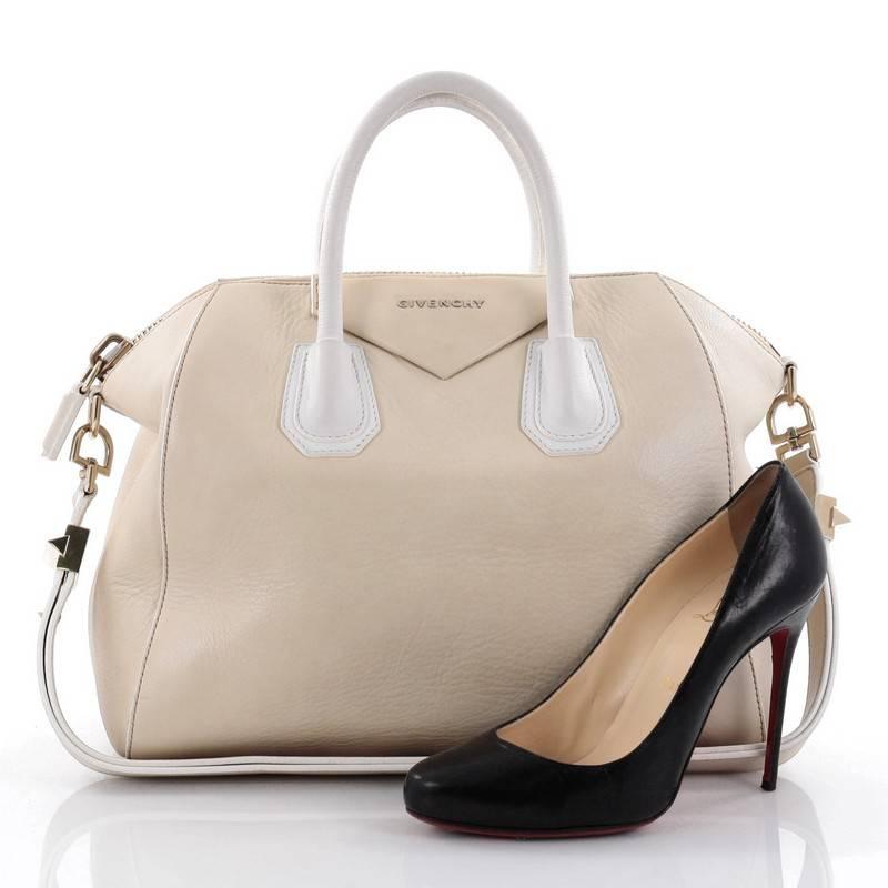 This authentic Givenchy Bicolor Antigona Bag Leather Medium is a go-to fashion favourite. Crafted from beige and white leather, this structured yet stylish tote features the brand's signature envelope flap detail with Givenchy logo, dual-rolled