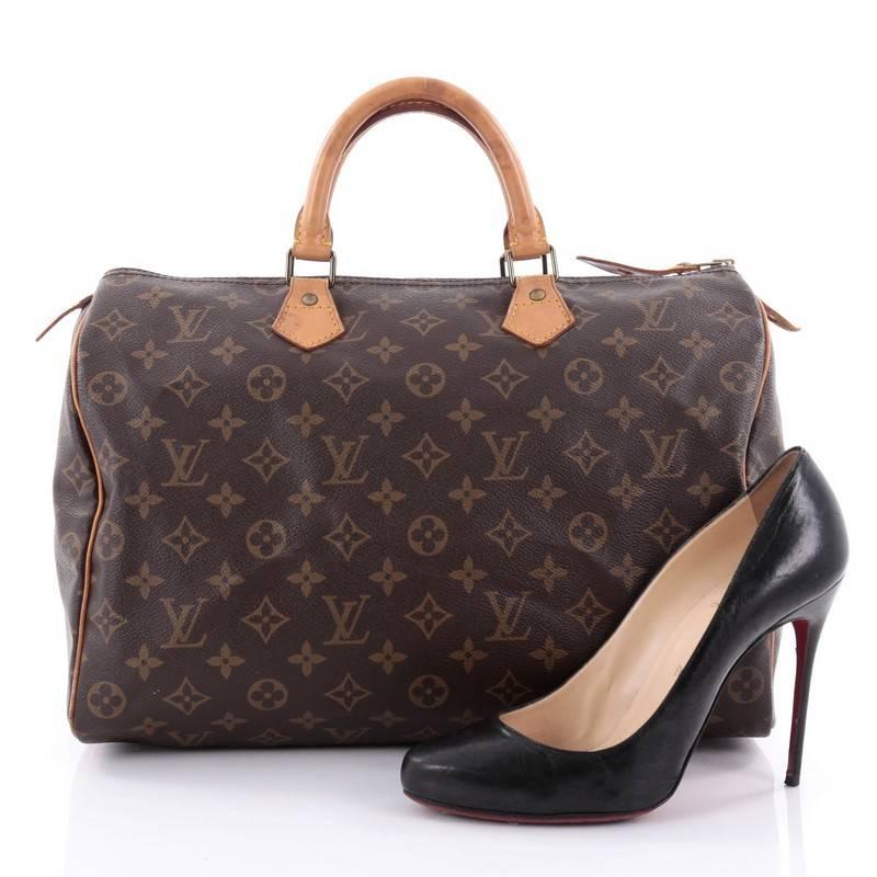 This authentic Louis Vuitton Speedy Handbag Monogram Canvas 35 is spacious and light, making it ideal to use everyday. Constructed in Louis Vuitton's classic brown monogram coated canvas, this iconic Speedy features dual-rolled leather handle,