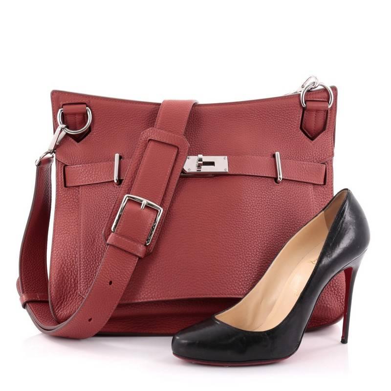 This authentic Hermes Jypsiere Handbag Clemence 34 is a current and favourite style among Hermes lovers. Inspired by the brand's iconic Kelly bag, this luxurious and industrial messenger is crafted in scratch-resistant brique red clemence leather