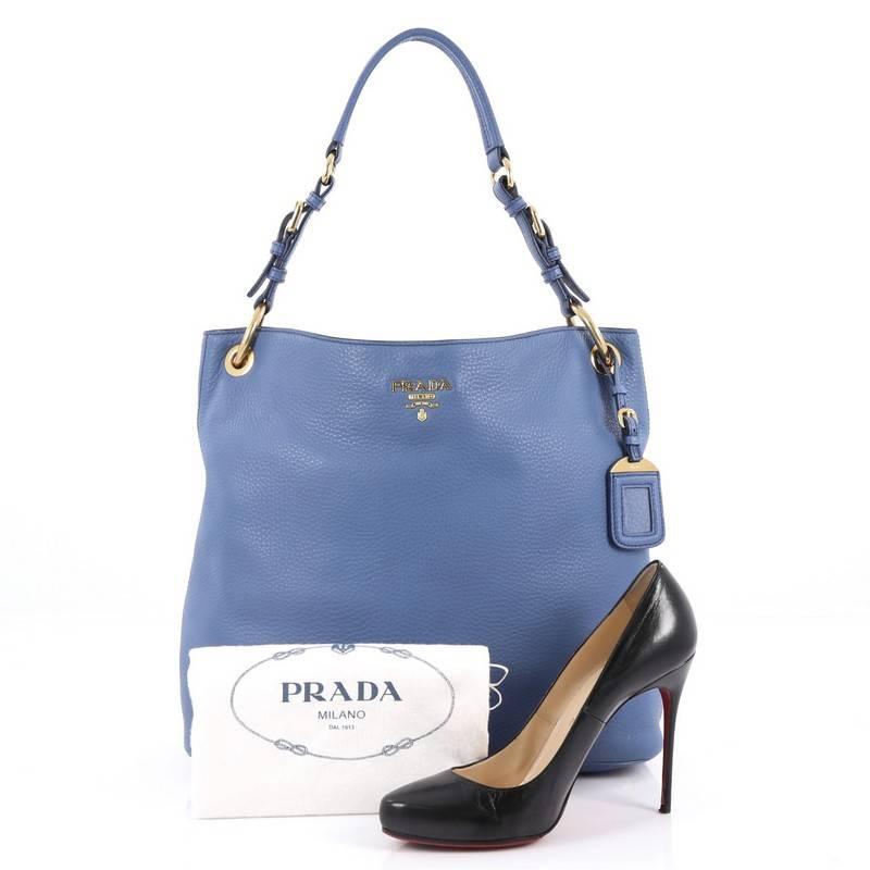 This authentic Prada Rolled Hobo Vitello Daino Large is great for comfort and style. Crafted from blue vitello daino leather, this slouchy no-fuss hobo features a rolled shoulder strap, gold hardware accents and Prada nameplate rests on the face of