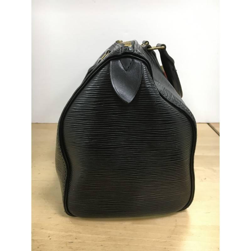This authentic Louis Vuitton Speedy Handbag Epi Leather 30 is a fresh twist on the classic Louis Vuitton speedy design. Crafted from sturdy black epi leather, this rounded bag features dual-rolled leather handles, subtle LV logo, exterior side
