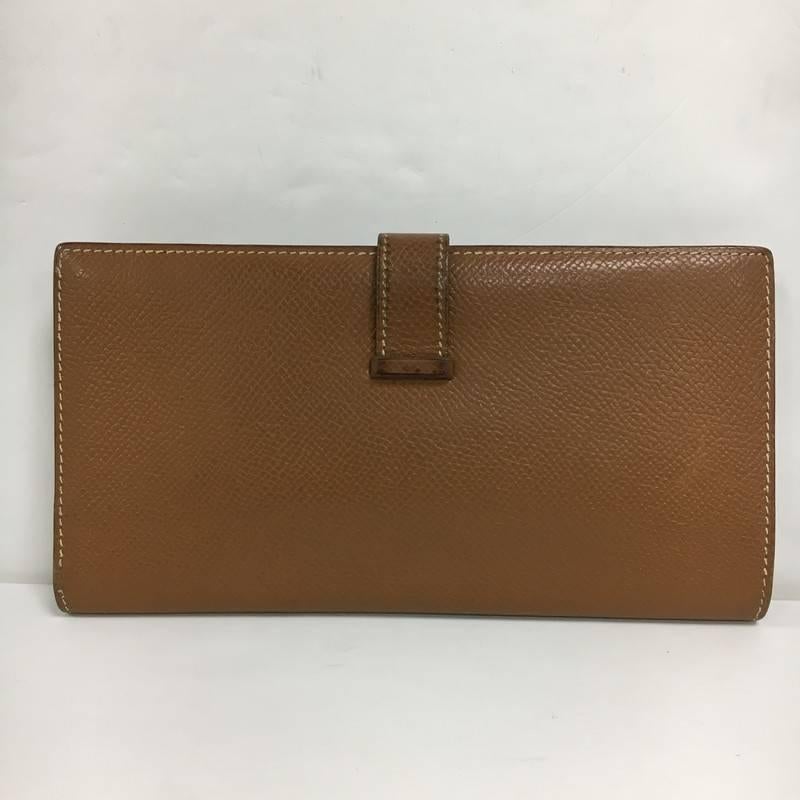 This authentic Hermes Bearn Wallet Courchevel Long is your perfect small accessory. Crafted from sumptuous brown leather featuring its gold-plated 'H' tab closure and gold-tone hardware accents. Its matching light brown leather-lined interior