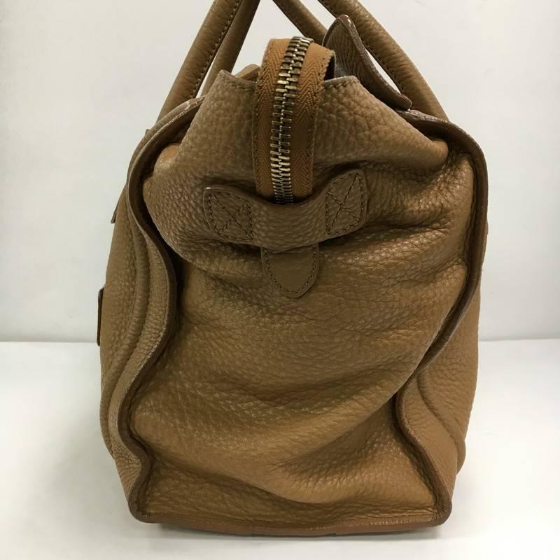 This authentic Celine Luggage Handbag Grainy Leather Mini epitomizes Phoebe Philo's minimalist yet chic style. Constructed in light brown grainy leather, this beloved fashionista's bag features dual-rolled leather handles, a frontal zip pocket,