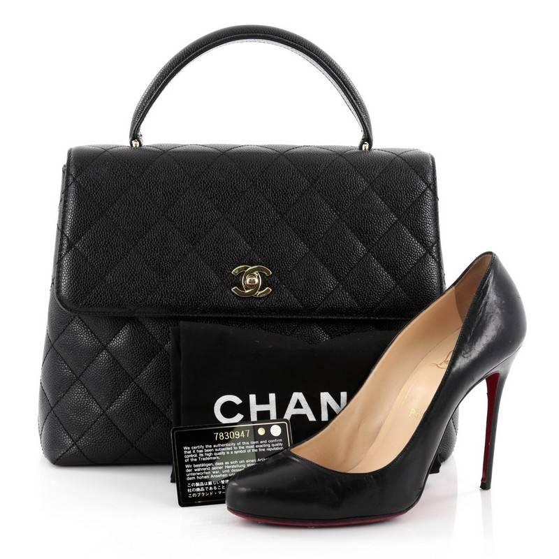 This authentic Chanel Vintage Classic Top Handle Flap Bag Quilted Caviar Jumbo showcases a timeless design perfect for any woman. Crafted in black diamond quilted caviar leather, this iconic top handle bag features a single looped top handle,