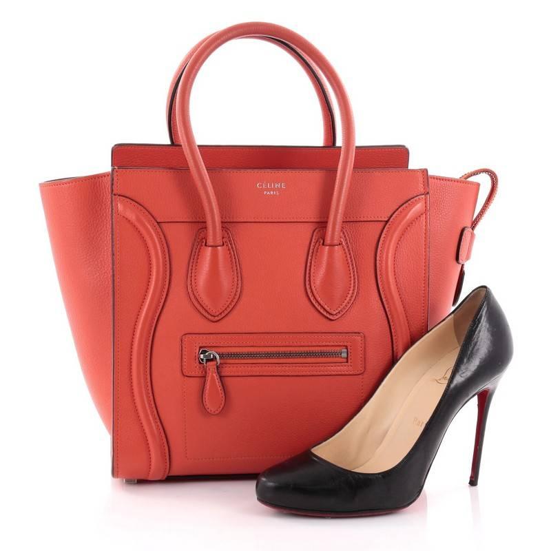 This authentic Celine Luggage Handbag Grainy Leather Micro is one of the most sought-after bags beloved by fashionistas. Crafted from red-orange grainy leather, this minimalist tote features dual-rolled handles, an exterior front pocket, protective