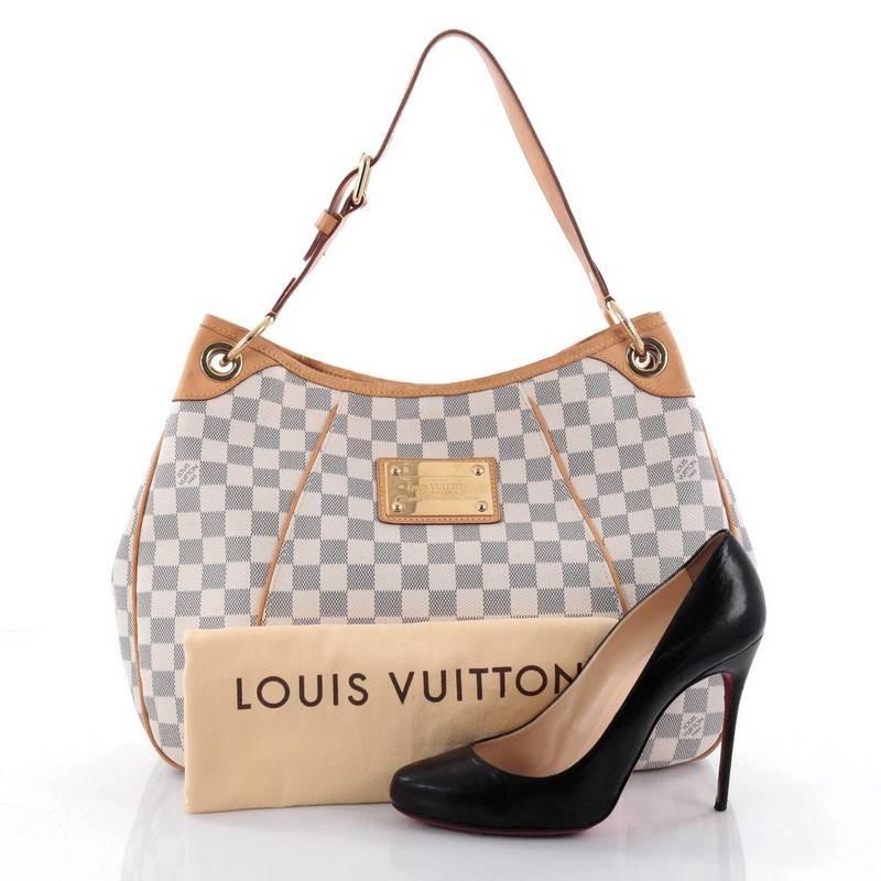 This authentic Louis Vuitton Galliera Handbag Damier PM is a practical and iconic bag that's a favourite among LV collector's everywhere. Crafted from Louis Vuitton's damier azur coated canvas, this bag features an adjustable belted leather shoulder