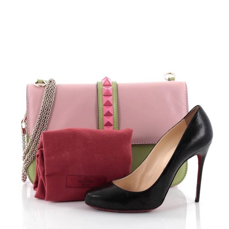 This authentic Valentino Glam Lock Shoulder Bag Leather Large is a fun, exciting and bold accessory perfect for nights out. Crafted from pink and green leather, this beautiful flap bag features a long gold-tone chain strap that allows it to be worn