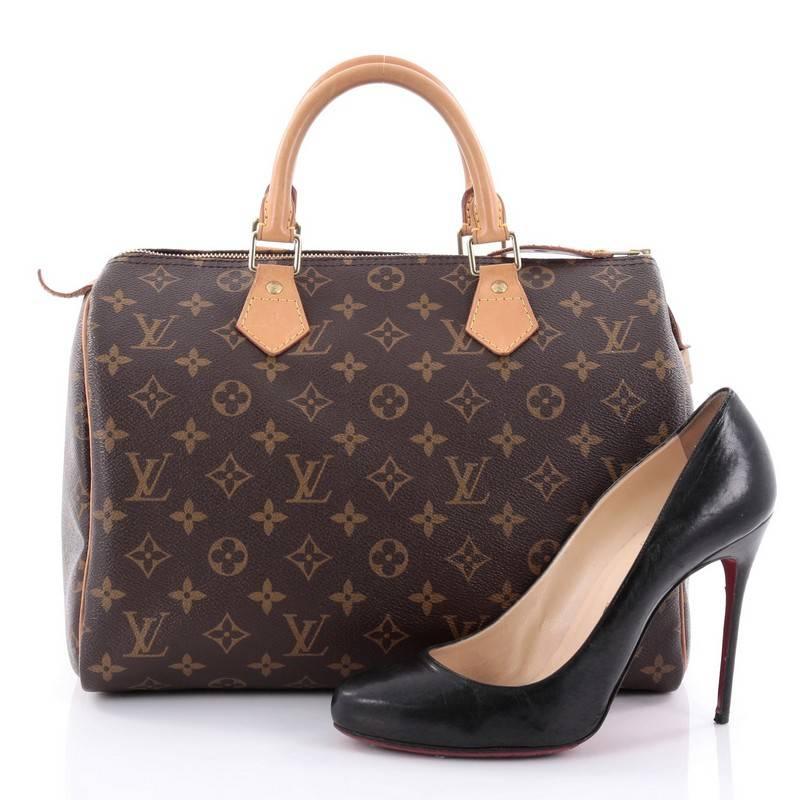 This authentic Louis Vuitton Speedy Handbag Monogram Canvas 30 is spacious and light, making it ideal to use everyday. Constructed in Louis Vuitton's classic brown monogram coated canvas, this iconic Speedy features dual-rolled leather handle,