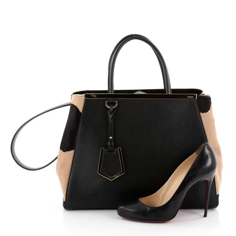 This authentic Fendi 2Jours Handbag Pony Hair and Leather Medium is impeccably stylish with a simple silhouette and structured design. Finely crafted in sturdy black leather with tan and black pony hair sides, this popular tote features a shining