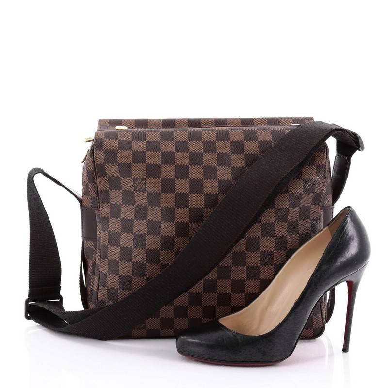 This authentic Louis Vuitton Naviglio Handbag Damier is perfect for the style-conscious man or woman on the go. Crafted from damier ebene coated canvas, this elegant bag features wide canvas adjustable strap, large dual flap design and gold-tone