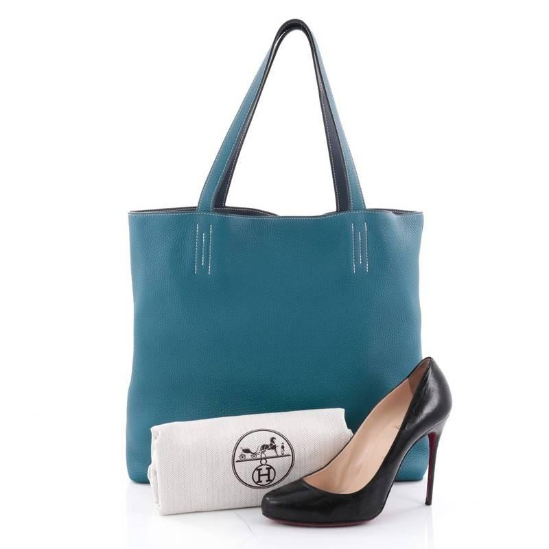This authentic Hermes Double Sens Tote Clemence 45 combines a simple and functional style from Hermes perfect for everyday use. Crafted from soft luxurious reversible veau taurillon clemence leather in bleu saphir and bleu izmir leather, this