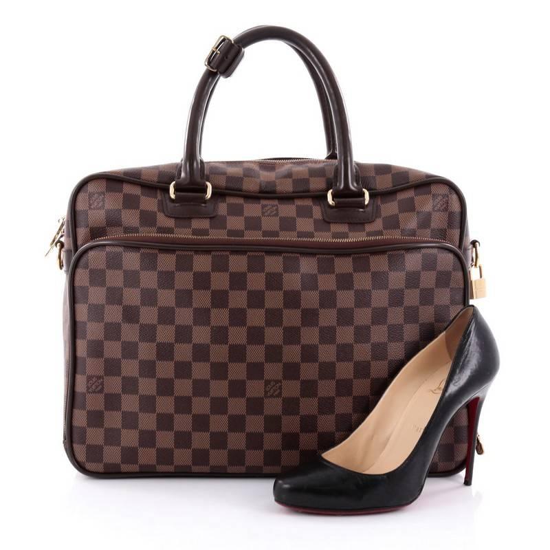 This authentic Louis Vuitton Icare Laptop Bag Damier combines luxurious style and functionality ideal for work. Crafted from damier ebene coated canvas, this stylish laptop bag features a structured, boxy silhouette, dual-rolled leather handles,