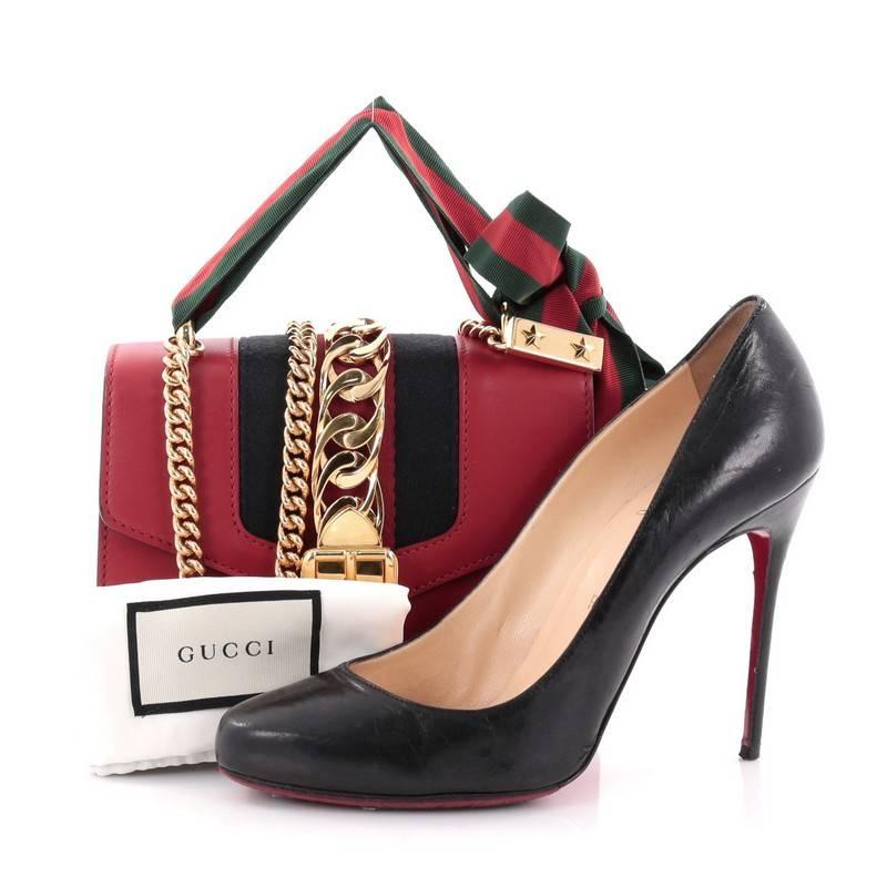 This authentic Gucci Sylvie Chain Shoulder Bag Leather Mini is a structured shape bag perfect for the modern fashionista. Crafted from red leather, this structured bag features chain shoulder strap, grosgrain Web bow with gold toned ends with stars,