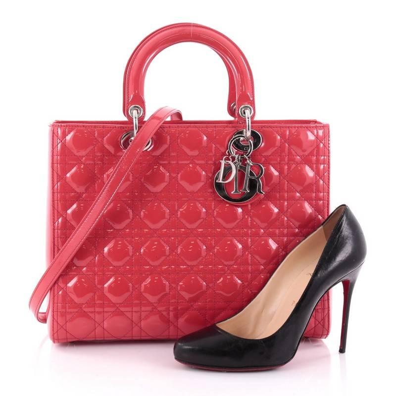 This authentic Christian Dior Lady Dior Handbag Cannage Quilt Patent Large is a classic staple that every fashionista needs in her wardrobe. Crafted from candy pink patent leather in Dior's iconic cannage quilting, this boxy bag features dual- flat