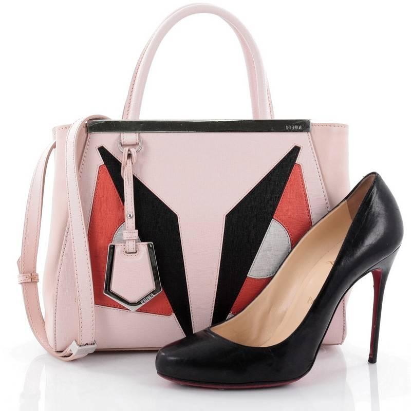 This authentic Fendi 2Jours Monster Handbag Calfskin Petite updates its popular design with an iconic, kitschy monster motif. Crafted from light pink leather, this structured tote features dual-rolled leather handles, a shining top bar with Fendi