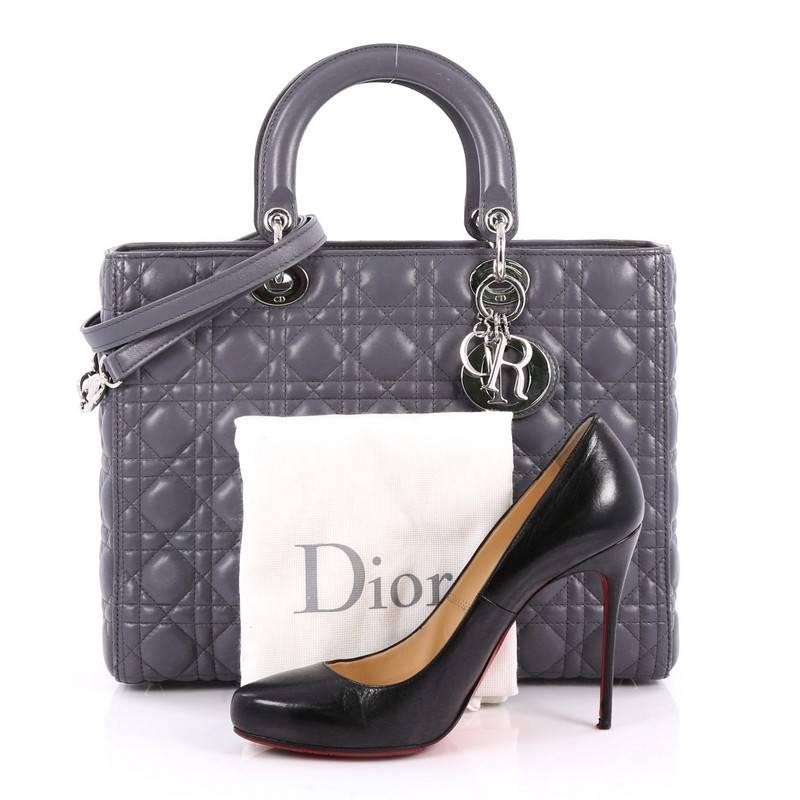 This authentic Christian Dior Lady Dior Handbag Cannage Quilt Lambskin Large is a classic staple that every fashionista needs in her wardrobe. Crafted from grey lambskin leather in Dior's iconic cannage quilting, this boxy bag features dual-rolled