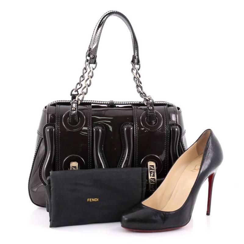 This authentic Fendi B. Bag Patent Medium is a chic bag with a roomy construction that is ideal for work and everyday use. Crafted from brown shimmer patent leather, this stylish bag features dual chain link straps with patent leather shoulder pads,