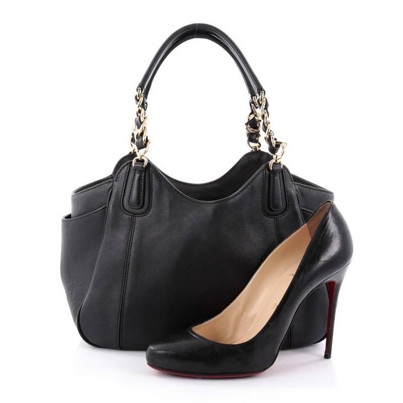 This authentic Salvatore Ferragamo Melinda Tote Leather Small is minimalist and classic in design, ideal for everyday use. Crafted from black leather, this elegant tote features woven-in leather chain strap with leather shoulder pads, exterior side