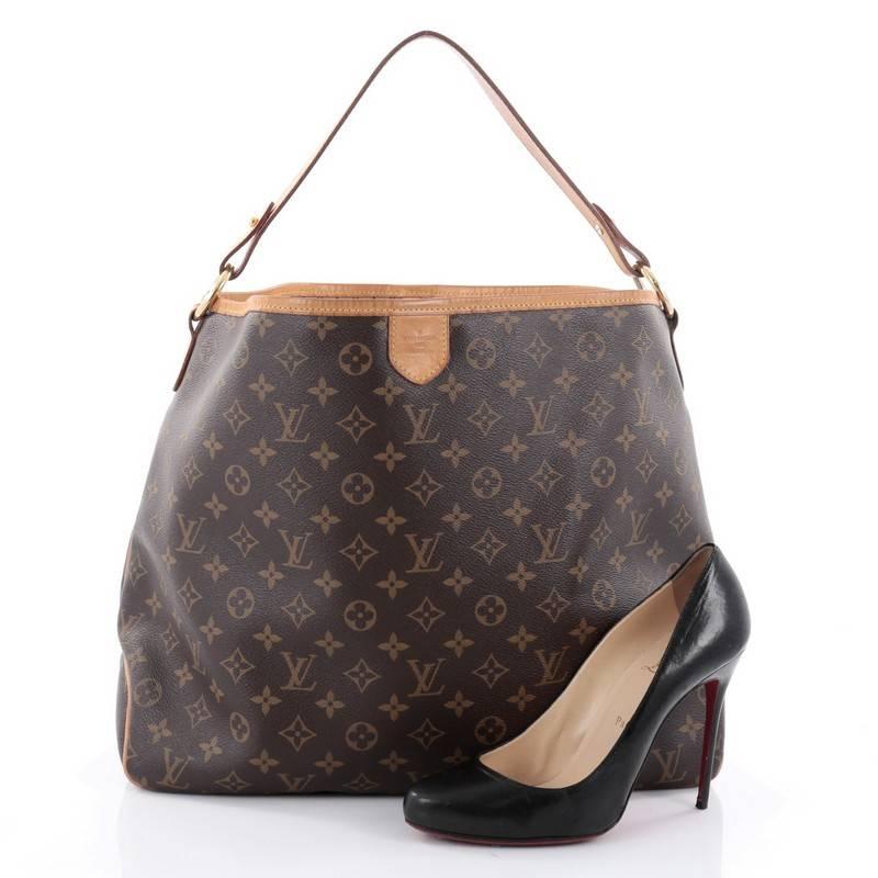 This authentic Louis Vuitton Delightful Handbag Monogram Canvas MM is a versatile hobo that can be used everyday. Constructed from the brand's classic brown monogram coated canvas with cowhide leather trims, this glamorous bag features flat leather