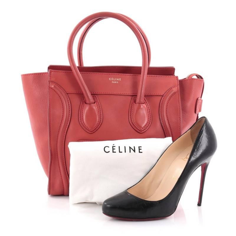 This authentic Celine Luggage Handbag Smooth Leather Micro is the quintessential It bag perfect for the modern woman. Crafted in red-orange smooth leather, this popular tote features gold Celine logo detail, dual-rolled leather handles, front zipped