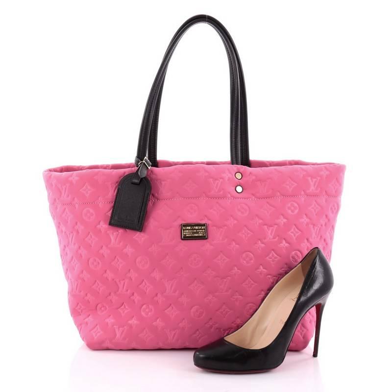 This authentic Louis Vuitton Scuba Tote Monogram Embossed Neoprene MM released in the brand's 2009 Cruise Collection is a stylish and functional bag made for everyday use or weekend getaways. Crafted from eye-catching hot pink monogram embossed