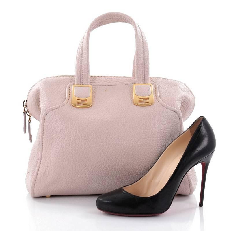 This authentic Fendi Chameleon Convertible Satchel Leather Small showcases a simple, classic design with a modern twist. Constructed in light mauve leather, this stylish satchel features dual top handles accented with gold Fendi FF logo hardware,