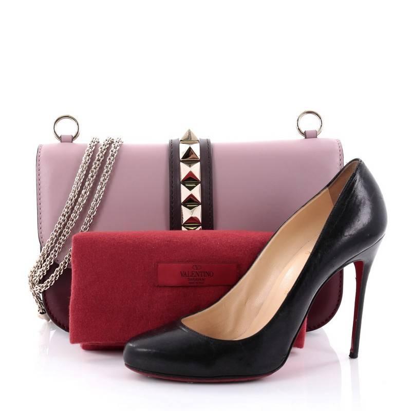 This authentic Valentino Glam Lock Shoulder Bag Leather Medium is a fun, exciting and bold accessory perfect for nights out. Crafted from contrasting mauve and maroon leather, this beautiful two-tone flap bag features a long gold-tone chain strap