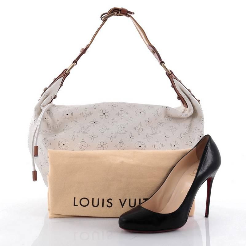 This authentic Louis Vuitton Onatah Hobo Mahina Leather GM is a stylish and functional must-have bag for LV lovers. Crafted from the brand's off-white mahina leather, this hobo features single a subtle perforated monogram design, adjustable textile