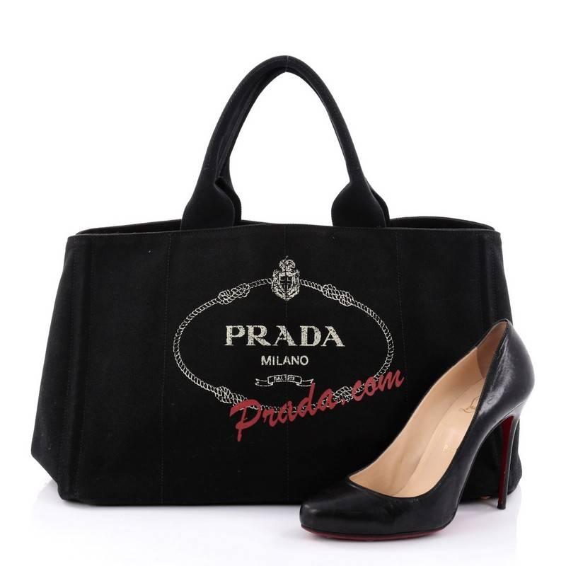This authentic Prada Canapa Tote Printed Canvas Large showcases the brand’s playful side with this limited edition piece. Crafted from nero black canvas, this tote features dual-roll handles, stamped lettering, Prada Milano logo on the side, side