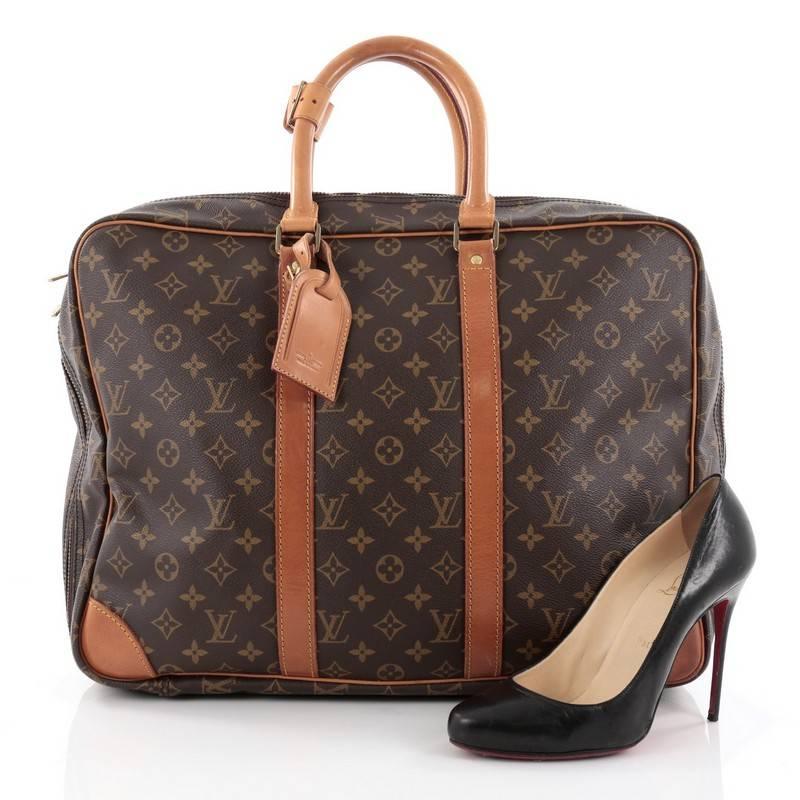 This authentic Louis Vuitton Porte-Documents Voyage Soft Compartment Briefcase Monogram Canvas showcases a traditional men's briefcase silhouette. Crafted from the brand's classic brown monogram coated canvas, this luxurious briefcase features