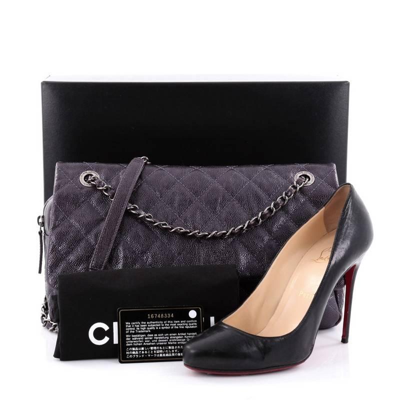 This authentic Chanel Easy Flap Bag Quilted Caviar Jumbo exudes a classic yet easy style made for the modern woman. Crafted from purple metallic caviar leather with Chanel's signature diamond quilting design, this elegant flap features woven-in